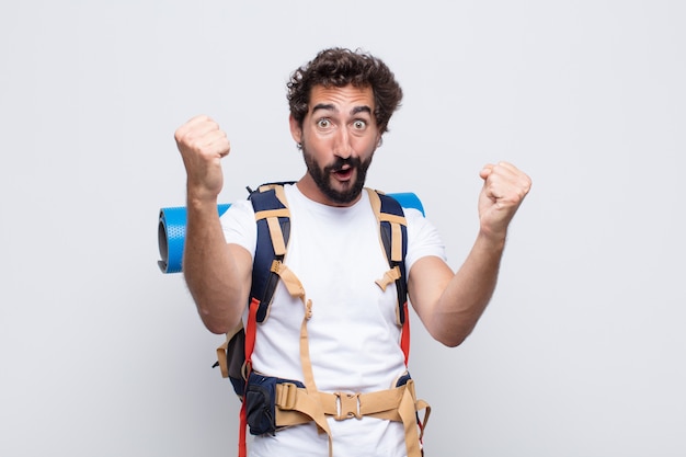 Jovem celebrando um sucesso inacreditável como um vencedor, parecendo animado e feliz dizendo 