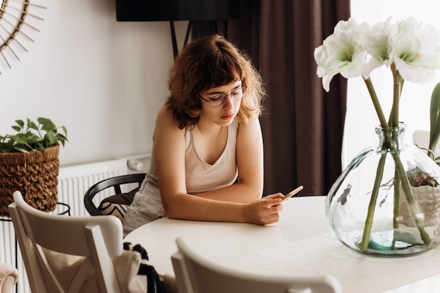 Jovem chateada lendo más notícias ao telefone. Adolescente assistindo vídeo triste no smartphone