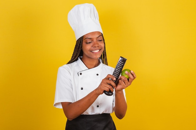 Jovem chef afro-brasileira cozinheira segurando limão e ralador para cozinhar