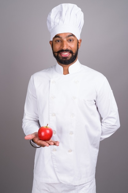 Jovem chef indiano segurando uma maçã