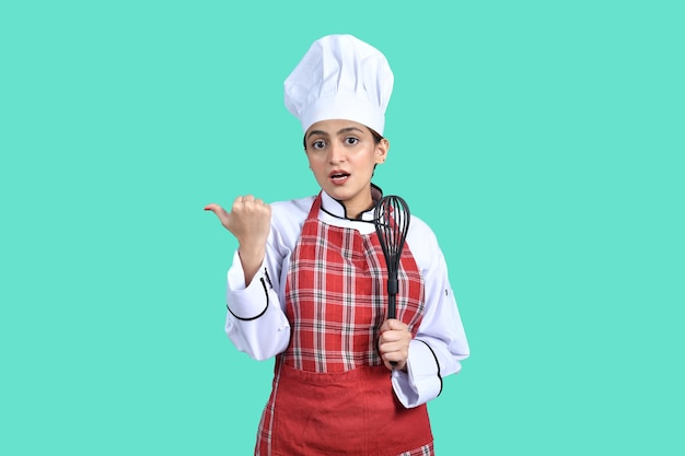 jovem chef menina roupa branca segurando colher de mistura modelo paquistanês indiano