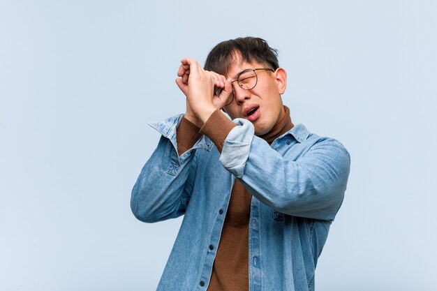 Jovem chinês, fazendo o gesto de uma luneta