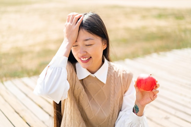 Jovem chinesa com uma maçã ao ar livre percebeu algo e pretende a solução