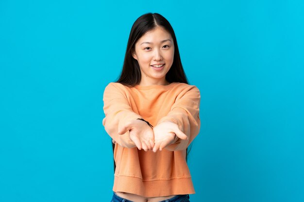 Jovem chinesa esticando as mãos para a frente