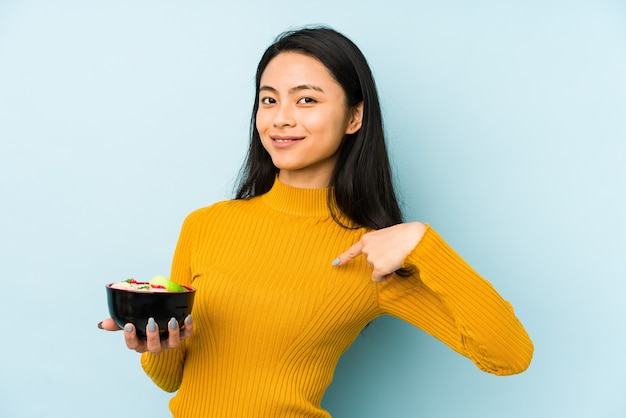 Jovem chinesa segurando macarrão isolado, sonhando em alcançar objetivos e propósitos