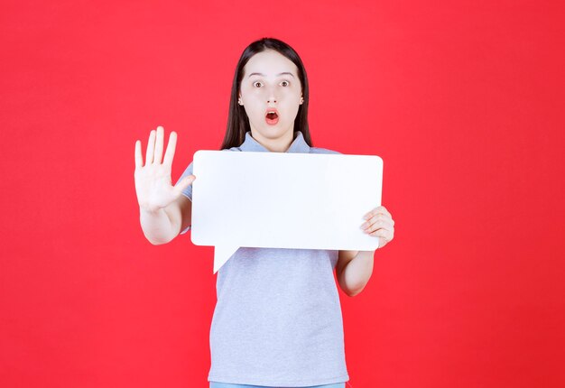 Foto jovem chocada segurando a prancha e gesticulando para parar