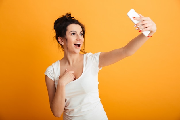 Jovem chocada usando telefone celular.