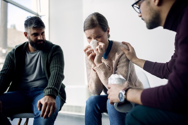 Jovem chorando enquanto participava de terapia de grupo no centro médico