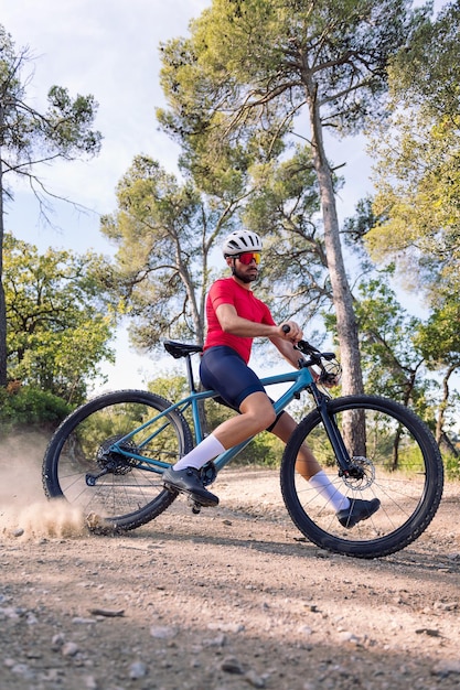 Jovem ciclista à deriva com sua bicicleta de montanha