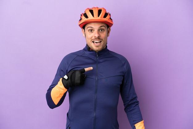 Jovem ciclista brasileiro isolado em um fundo roxo com expressão facial surpresa