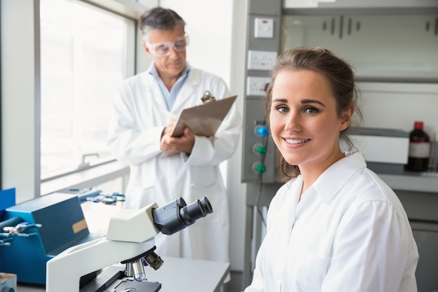 Jovem cientifica sorrindo para a câmera