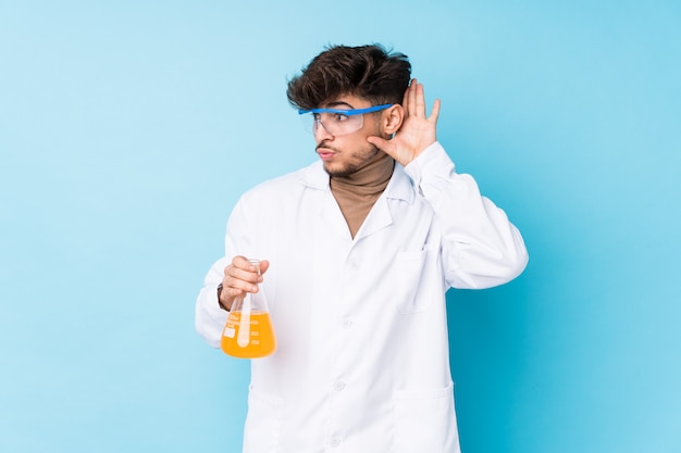 Jovem cientista árabe isolado tentando ouvir uma fofoca.