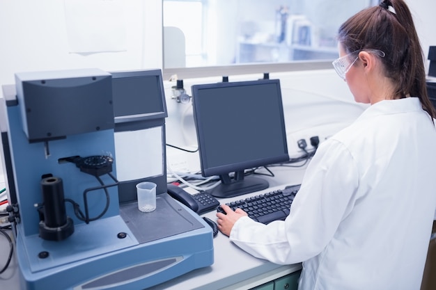 Jovem cientista digitando no computador