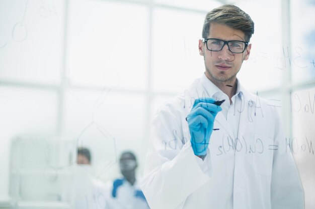 Foto jovem cientista fazendo anotações na placa de vidro no momento do experimentofoto com espaço de cópia