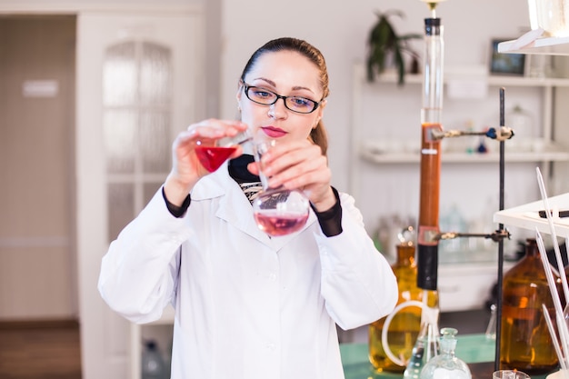 Jovem cientista feminina toma uma solução de amostra