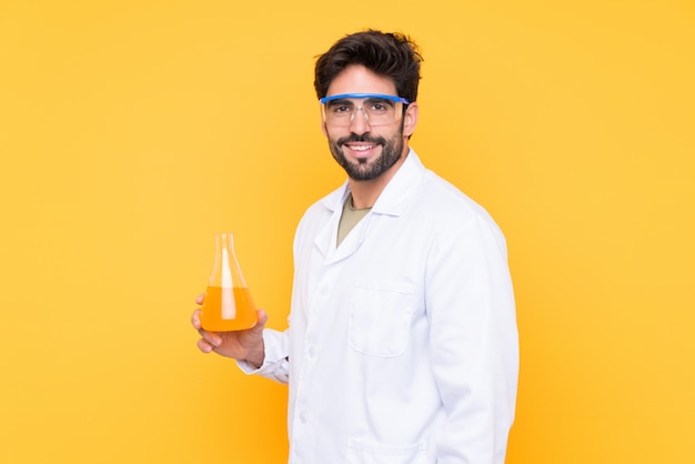 Jovem cientista isolado parede amarela sorrindo muito