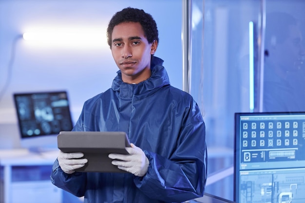 Jovem cientista masculino vestindo traje de proteção completo em laboratório