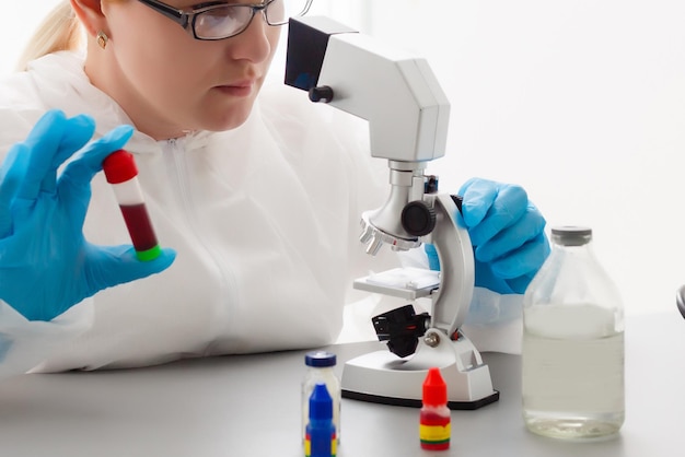 Jovem cientista procurando por um microscópio o vírus Covid-19 em um laboratório. Protective Epidemic Corona Virus, Covid-19 outbreak concept