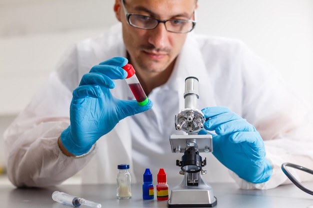 Jovem cientista procurando por um microscópio o vírus Covid-19 em um laboratório. Protective Epidemic Corona Virus, Covid-19 outbreak concept