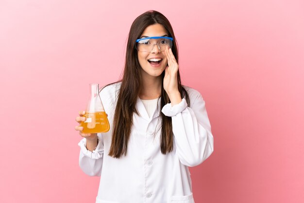 Jovem cientista sobre fundo rosa isolado gritando com a boca bem aberta