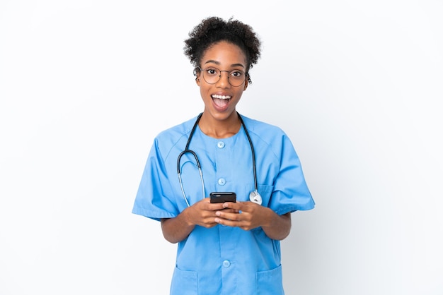 Jovem cirurgião afro-americano médico isolado em fundo branco surpreso e enviando uma mensagem