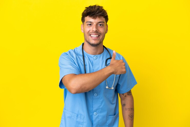 Foto jovem cirurgião médico homem isolado em fundo amarelo fazendo um gesto de polegar para cima