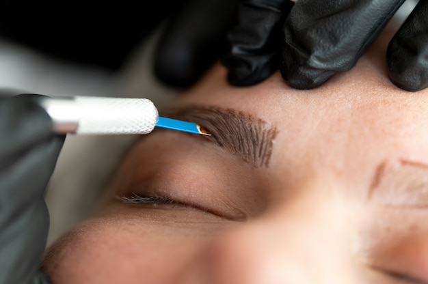 Jovem cliente passando por um procedimento de microblading