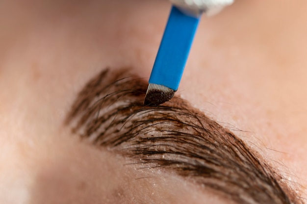 Foto jovem cliente passando por um procedimento de microblading