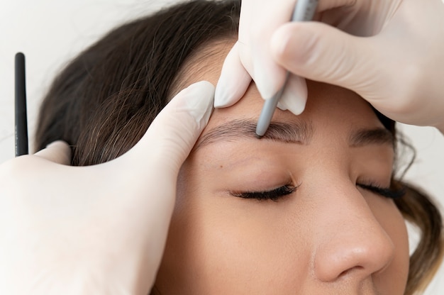 Jovem cliente passando por um procedimento de microblading