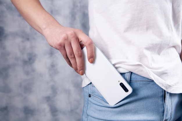 Jovem coloca o telefone no bolso