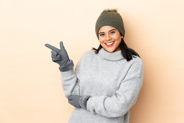 Jovem colombiana com chapéu de inverno isolado em bege