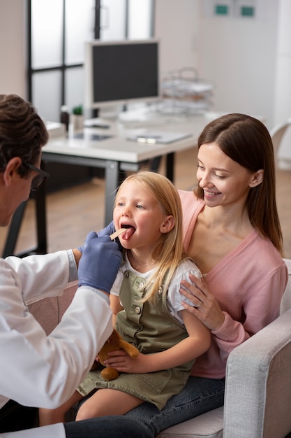 Foto jovem com a mãe no consultório do médico para um exame físico