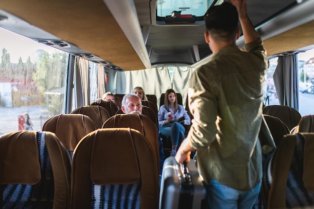 Foto jovem com bagagem de mão no ônibus.