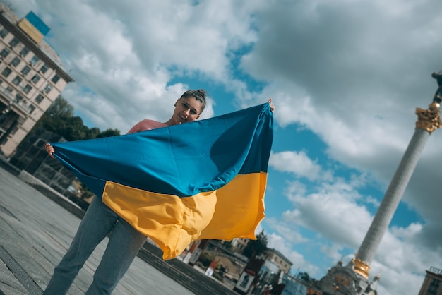 Jovem com bandeira nacional da Ucrânia na rua