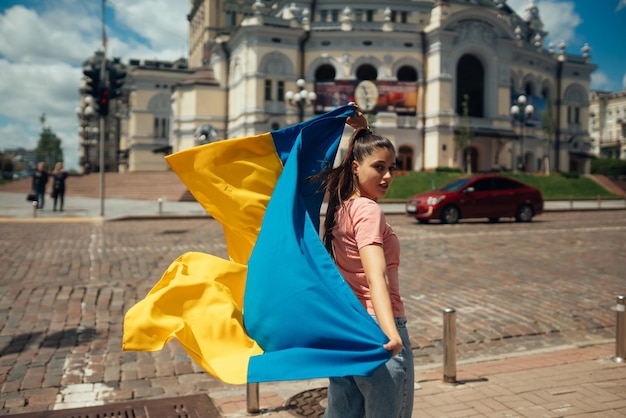 Jovem com bandeira nacional da Ucrânia na rua