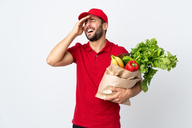 Foto jovem com barba segurando uma sacola cheia de vegetais