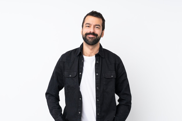 Jovem com barba sobre parede branca isolada rindo