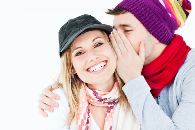 jovem com boné sussurrando algo para sua amiga