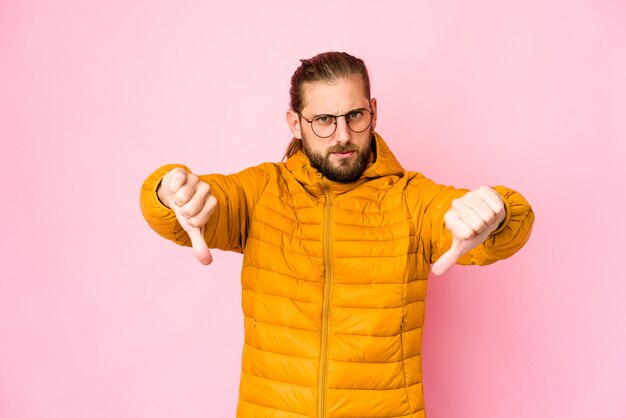 Jovem com cabelo comprido aparentando mostrar o polegar para baixo