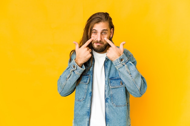 Jovem com cabelo comprido parece chorar, infeliz com o conceito de algo, agonia e confusão.