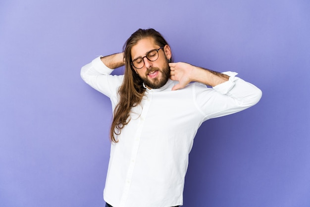 Jovem com cabelo comprido parece esticar os braços, posição relaxada.