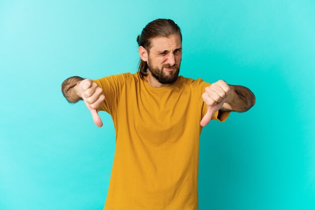 Jovem com cabelo comprido parece mostrando o polegar para baixo, o conceito de decepção.