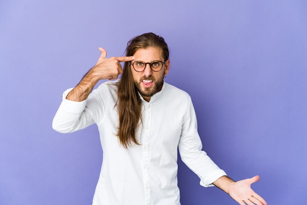 Jovem com cabelo comprido parece mostrando um gesto de decepção com o dedo indicador.