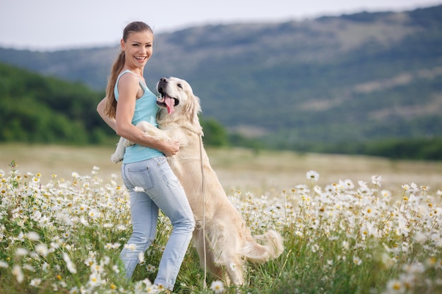 Jovem com cachorro em um campo de camomila