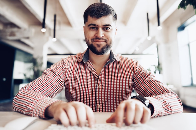 Jovem com camisa casual trabalhando no computador no escritório