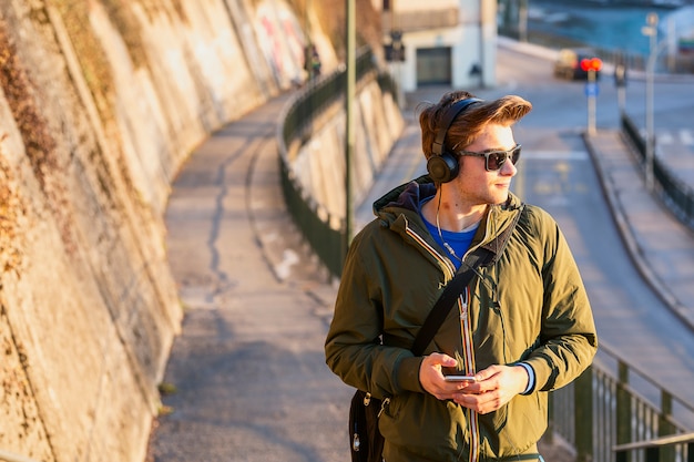 Jovem com celular na rua