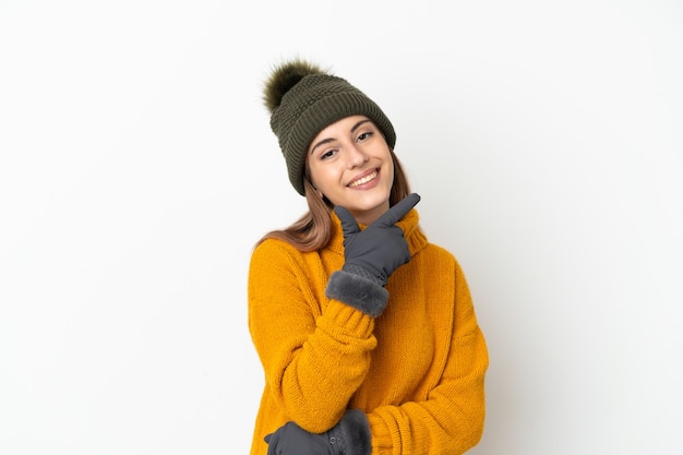 Jovem com chapéu de inverno isolado no fundo branco feliz e sorridente