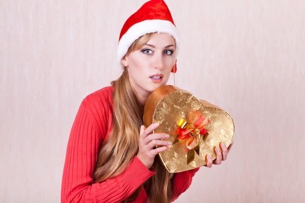 Jovem com chapéu de Papai Noel e caixa de presente