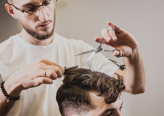 Jovem com corte de cabelo na moda na barbearia.