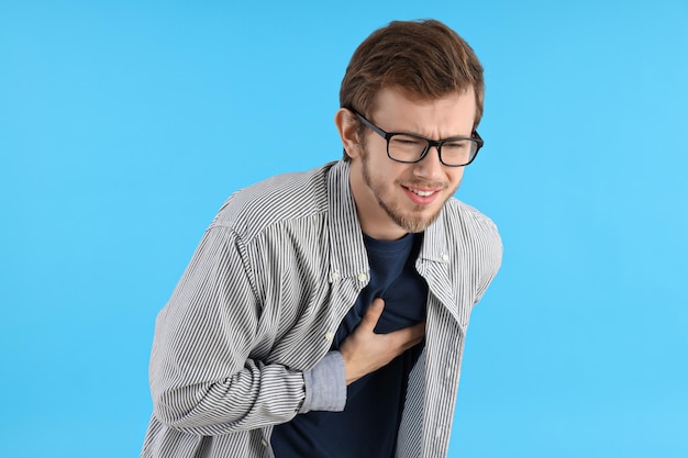 Jovem com dor no fundo azul